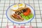 traditional breakfast on a plate on a table with a plaid tablecloth.