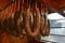Traditional breakfast sausage hanging in a smokehouse. Family gathering for a food preservation.