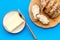 Traditional breakfast. Wholegrain bread on cutting board with butter on blue background top view