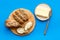 Traditional breakfast. Wholegrain bread on cutting board with butter on plate on blue background top view