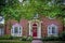 Traditional brick house with bay windows and pillars in summer with landscaping and door wreath and No soliciting sign and large