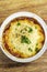 Traditional british cottage pie bowl meal on rustic wood table