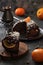 Traditional British steam chocolate pudding with oranges, clementines and coconut shreds served with coffee on wood slab on black