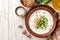 Traditional bulgarian cold summer soup tarator with yogurt, dill, cucumber and walnuts in ceramic bowl on wooden table