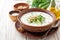 Traditional bulgarian cold summer soup tarator with yogurt, dill, cucumber and walnuts in ceramic bowl on wooden table