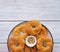 Traditional buttery twisted Italian Easter cookies with multicolored sugar decor on a white plate on a white wooden background.