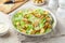 Traditional Caesar salad with lettuce, roasted chicken,  croutons and cheese in white bowl