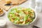 Traditional Caesar salad with lettuce, roasted chicken,  croutons and cheese in white bowl