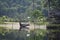 Traditional Cambodian long river boat pulled up on the beach by a wooden house in the jungle