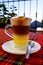Traditional Canarian coffee Barraquito with separated layers of milk condensed and liquor on the terrace of cafe in Tenerife,Canar