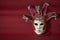 Traditional carnival venetian mask with rich decor on a red background, selective focus