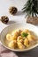 Traditional Catalan Christmas dish Escudella in white plate on table, stuffed pasta in meat broth, top view