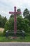 Traditional Catholic cachapel near the road in the shape of a cross with plastic artificial flowers, Biale, Poland