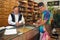 Traditional Chinese herbalist prepares herbs for customer who is with his 5-year-old daughter Chinatown in Oakland, CA