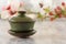 Traditional Chinese porcelain green tea cup stands on a gray table