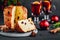 Traditional Christmas Panettone cake with dried fruits on dark stone background