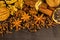 Traditional Christmas spices - Star anise with cinnamon and cloves and wallnuts on black rustic wooden background. Medicinal