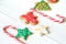 Traditional Christmas sweets on white wooden background. Candy cane, round snowflake and ginger man, star lollipop. Top