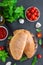 Traditional closed Italian calzone pizza with tomato sauce, mozzarella cheese and mushrooms on a board on a dark background.