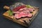 Traditional Commonwealth Sunday roast with sliced cold cuts roast beef with herbs and salt on a rustic wooden cutting board