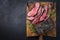 Traditional Commonwealth Sunday roast with sliced cold cuts roast beef with thyme and salt on a rustic wooden cutting