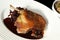 traditional confit french crispy skin on duck leg with braised red cabbage