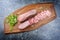 Traditional cooked beef tongue with pistachios and spices on a design wooden board