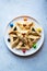 Traditional cookies for Jewish holiday Purim - Hamantashen with different fillings and colorful candies on a plate. Festive baking