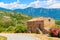 Traditional Corsican house built from stones along a road in mountain landscape of Corsica island, France