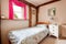 Traditional cottage bedroom with pink curtains and exposed beams