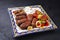 Traditional Croatian cevapi spicy meat ball rolls with BBQ vegetable and tzatziki on a rustic plate