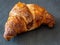 Traditional croissant placed on a dark plate