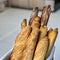 Traditional crusty French bread baguette in basket at bakery. Fresh organic pastry at local market. France cuisine background