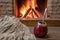 Traditional cup for mate drinking and wool scarf, near cozy fireplace, in country house