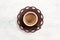 Traditional cup of Turkish coffee with foam on white wooden background. Top view