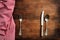 Traditional cutlery and red tablecloth on wooden table, top view, copy space