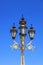 Traditional decorative lamp post against blue sky background