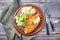 Traditional deep-fried schnitzel with potato and cucumber salad on a rustic wooden board