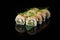 Traditional delicious fresh sushi roll set on a black background with reflection. Sushi roll with rice, nori, cream cheese, tobiko
