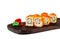 Traditional delicious fresh sushi roll on a wooden board, isolate. Sushi roll with rice, tofu cheese, red flying fish caviar, crab