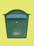 Traditional delivery green metal mail box isolated on yellow