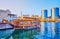 Traditional dhow cruise boat on Dubai Creek against the Deira Twin Towers, on March 1 in Dubai, UAE