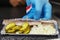 Traditional Dutch appetizer of herring, onions and pickles on a paper disposable plate. Close-up