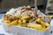 Traditional Dutch fast food dish, fried potatoes with sate sauce, onion and mayonaise, fat and not healthy street food