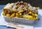 Traditional Dutch fast food dish, fried potatoes with sate sauce, onion and mayonaise, fat and not healthy street food