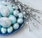 Traditional Easter dyed eggs and willow branches on a spring tablecloth. Easter celebration.