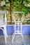 Traditional Egyptian metal tea table and white wooden chair on background of green climber plant