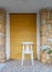 Traditional Egyptian white wooden chair over in front of bricks stone wall and yellow roll-up door