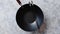 Traditional empty black iron wok pan placed on stone background