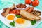 Traditional English breakfast: bacon, mushrooms, eggs, tomatoes, sausages, beans, toast on a white plate